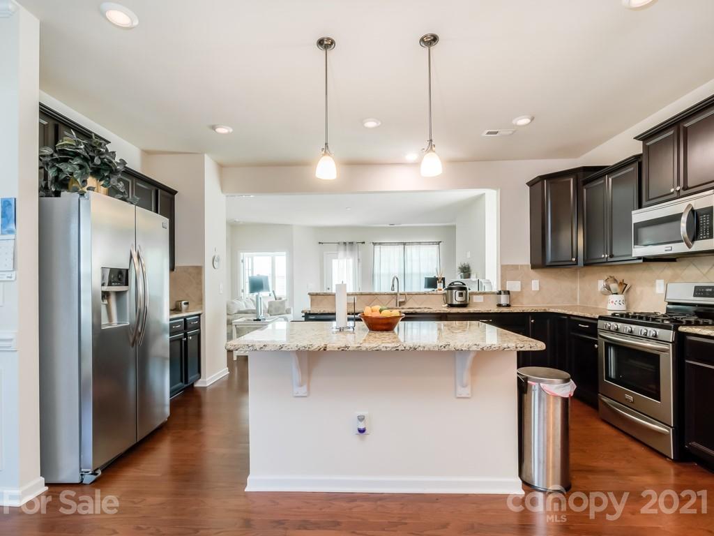 4142 Perth Road Indian Land, SC 29707 - Photo 23 of 26 a kitchen with stainless steel appliances granite countertop a sink a stove and a refrigerator