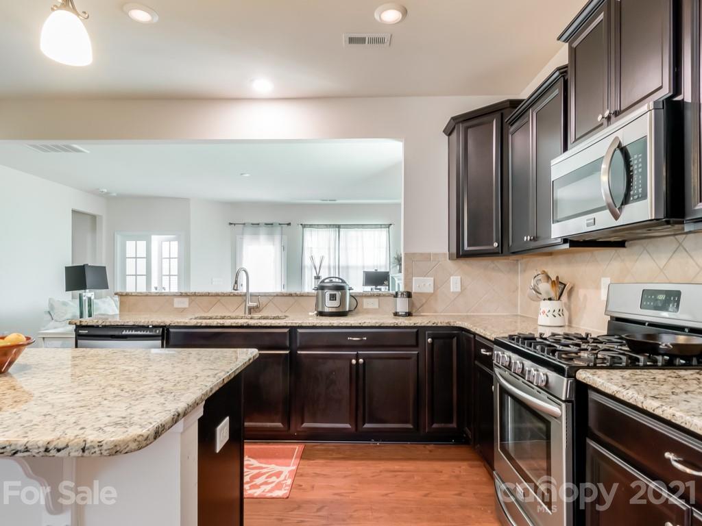 4142 Perth Road Indian Land, SC 29707 - Photo 10 of 26 a kitchen with stainless steel appliances granite countertop a sink stove and microwave