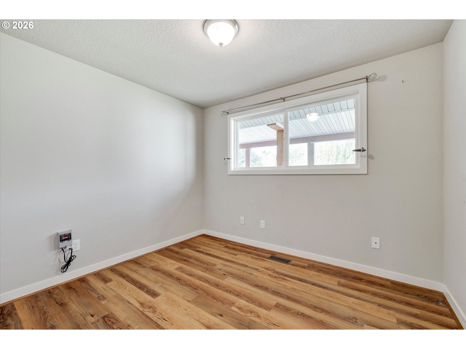 17139 South Bradley Road Oregon City, OR 97045 - Photo 17 of 47 a view of an empty room with wooden floor and a window