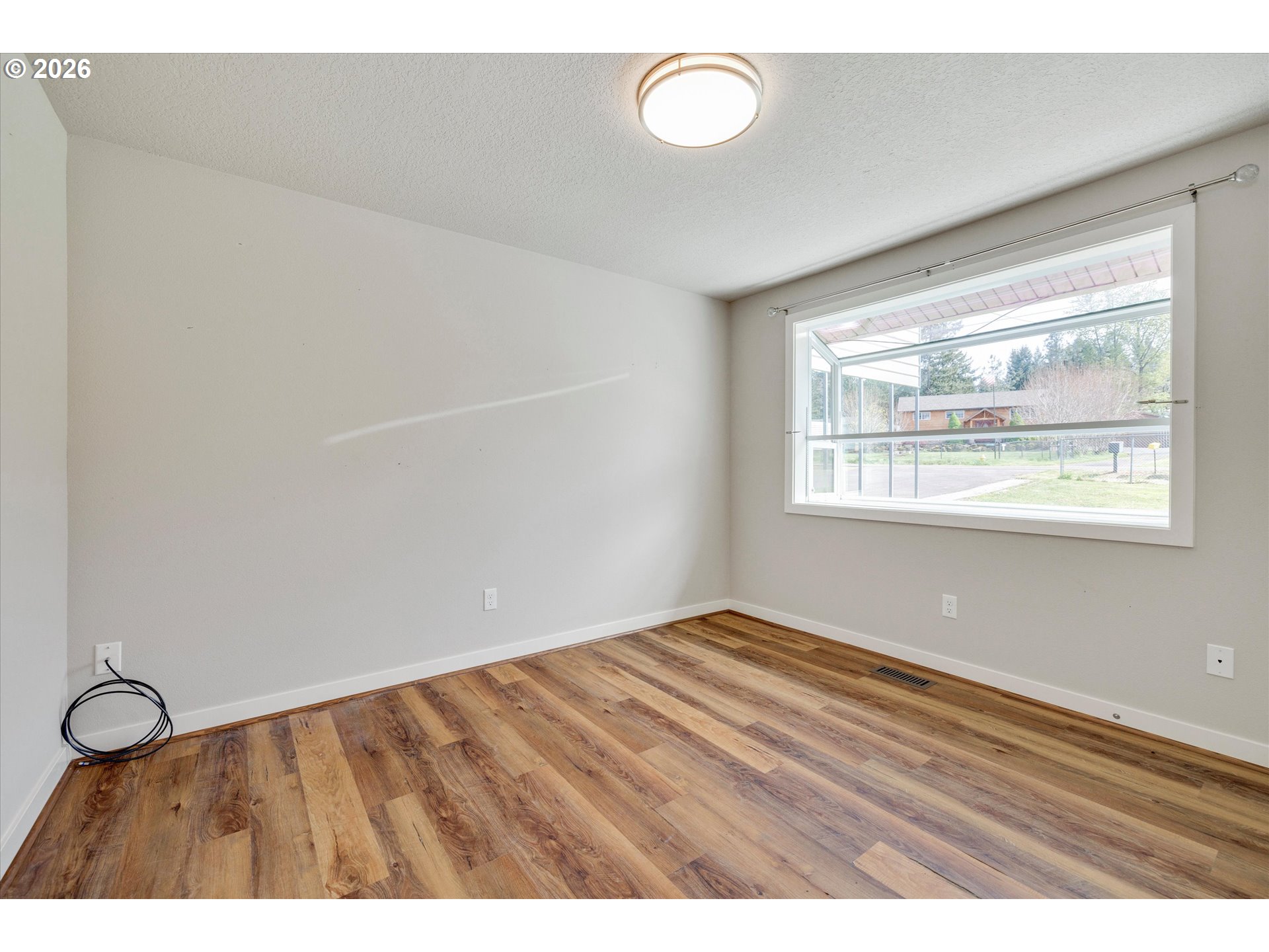 17139 South Bradley Road Oregon City, OR 97045 - Photo 19 of 47 a view of an empty room with wooden floor and a window
