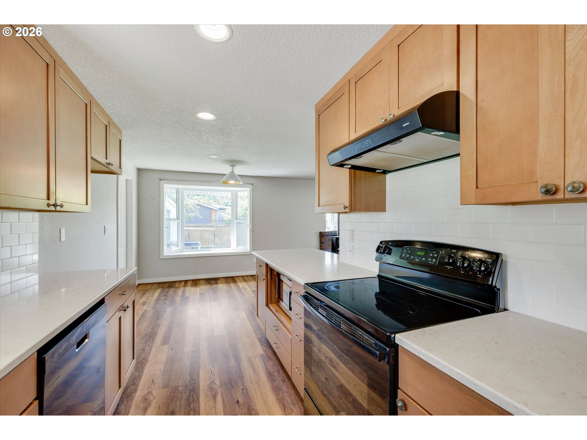 17139 South Bradley Road Oregon City, OR 97045 - Photo 9 of 47 a kitchen with a wooden floor and black appliances