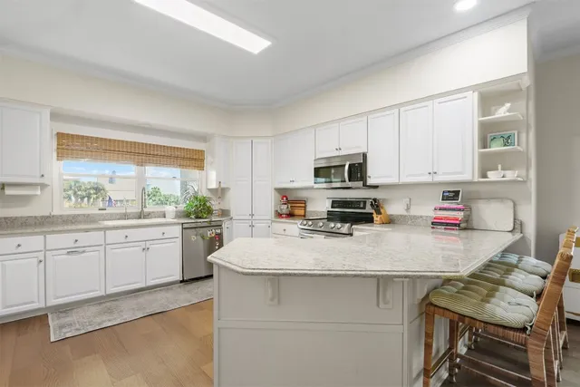 a kitchen with stainless steel appliances a stove refrigerator sink and microwave