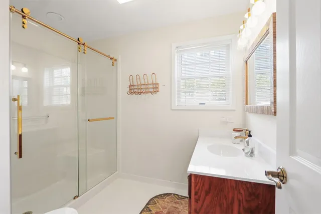 a bathroom with a sink a toilet and shower