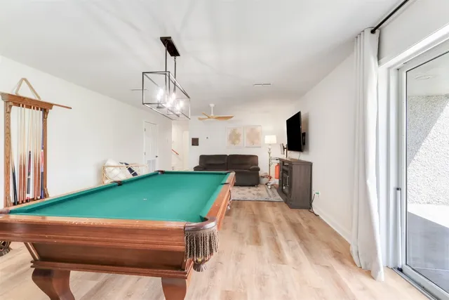 a room with pool table windows and a flat screen tv