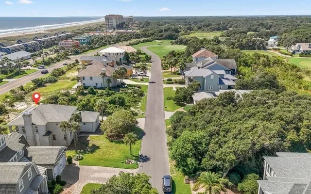 an aerial view of residential houses with outdoor space and trees