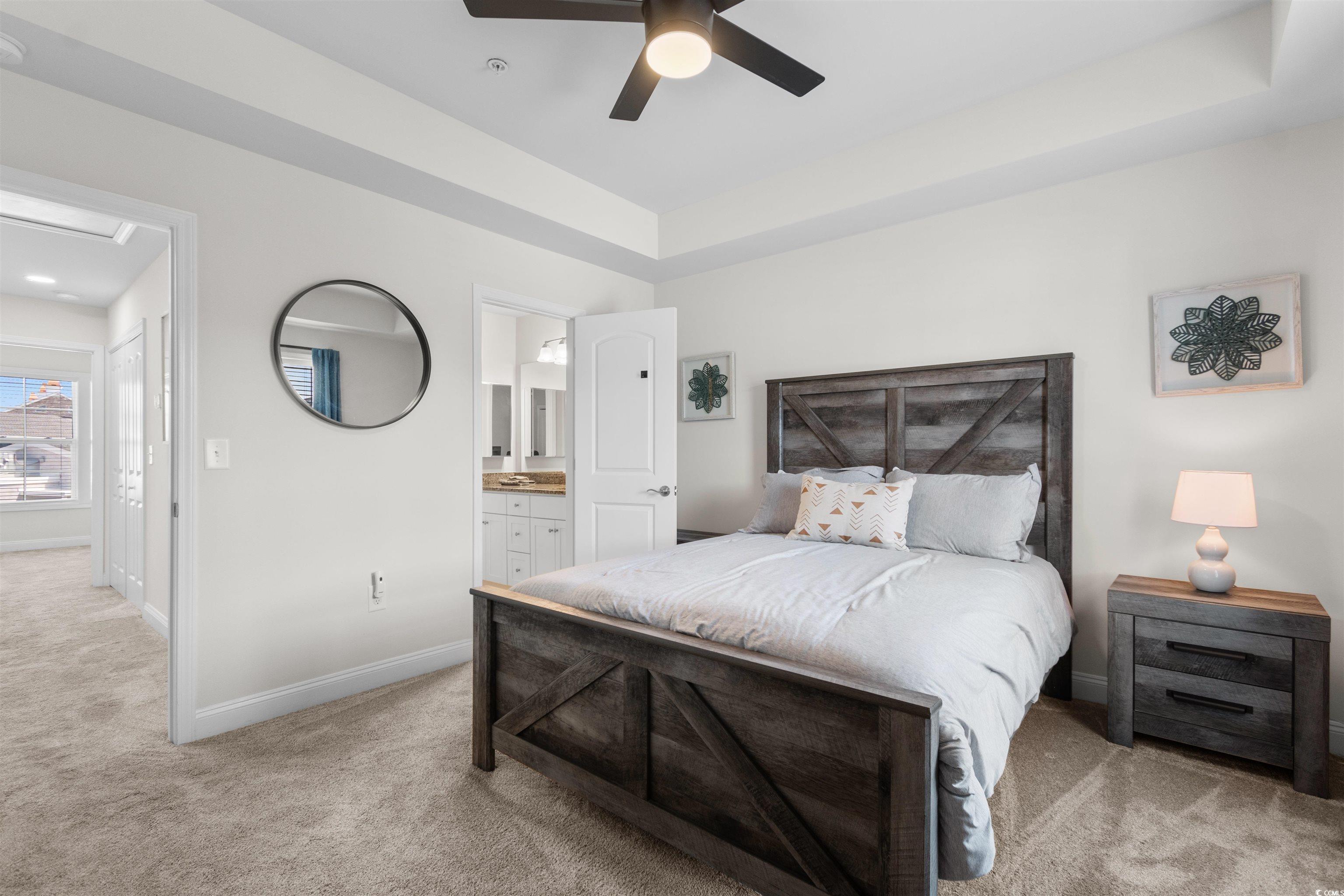 804 Moen Place, Unit F Myrtle Beach, SC 29577 - Photo 16 of 34 Bedroom with light colored carpet, a tray ceiling, a ceiling fan, and ensuite bath