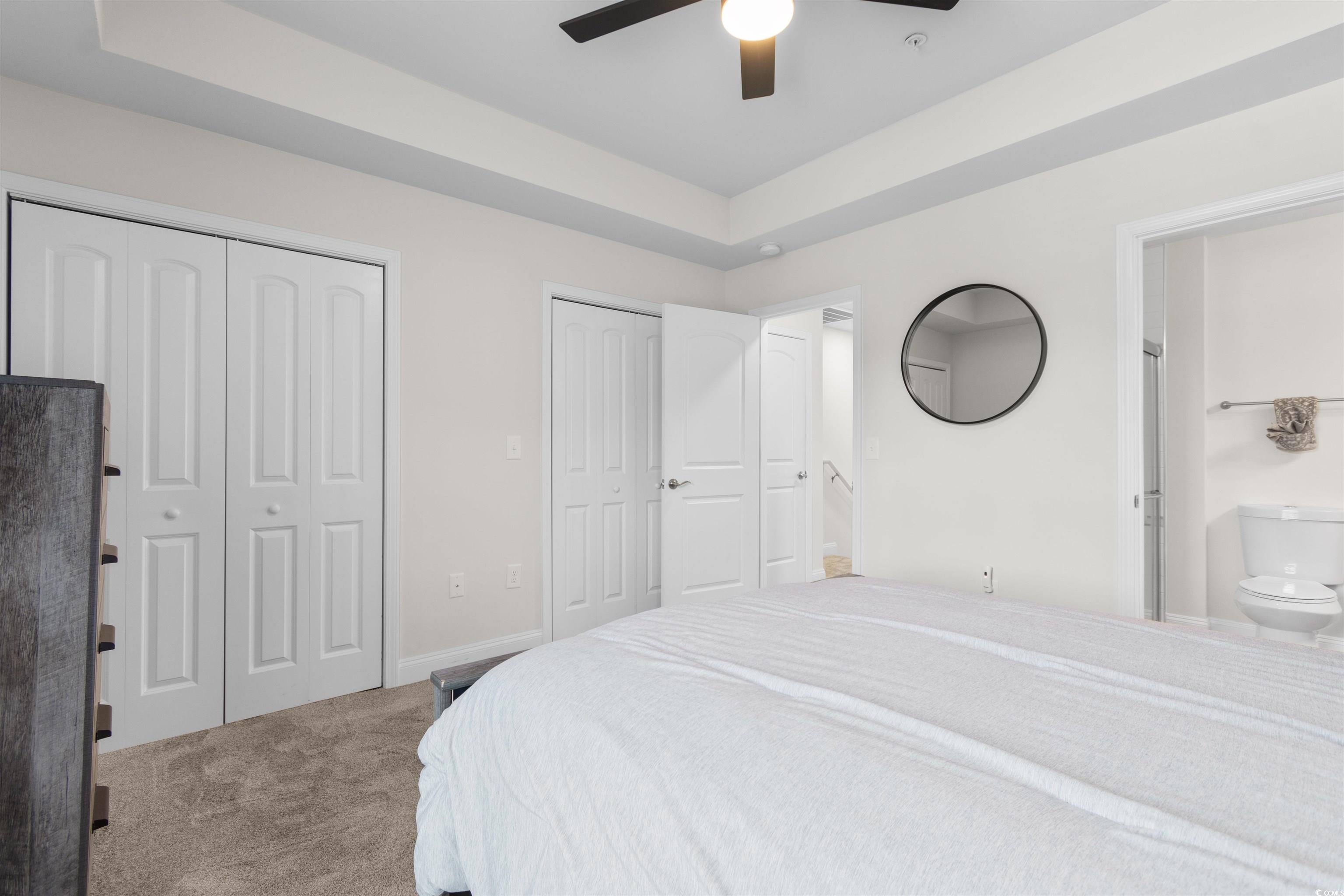 804 Moen Place, Unit F Myrtle Beach, SC 29577 - Photo 17 of 34 Carpeted bedroom featuring a tray ceiling, two closets, and ceiling fan