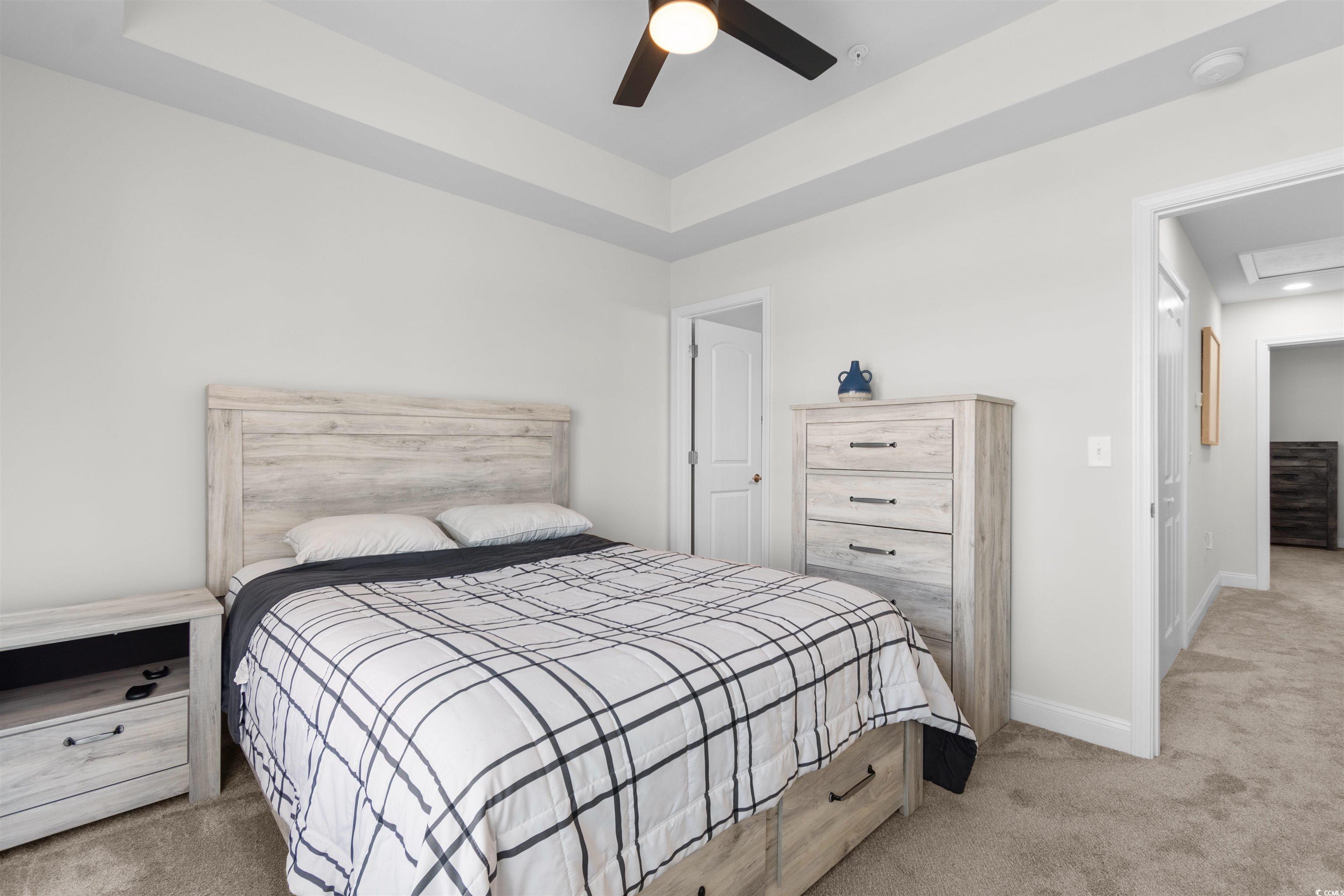 804 Moen Place, Unit F Myrtle Beach, SC 29577 - Photo 21 of 34 Bedroom with light carpet, a tray ceiling, and ceiling fan