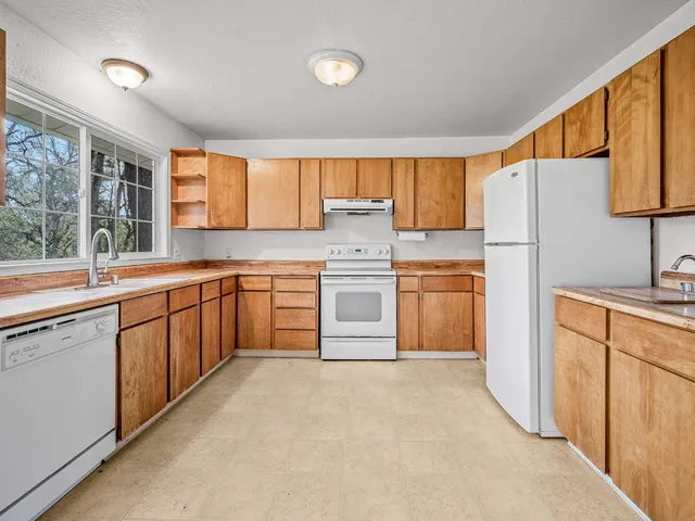 a kitchen with granite countertop a stove sink and cabinets