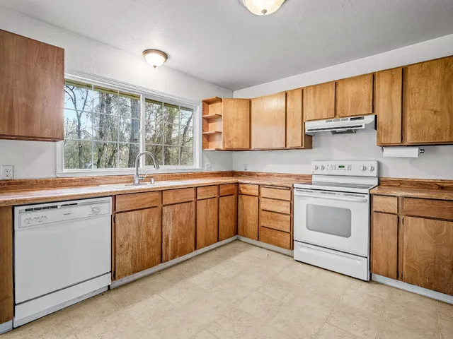 a kitchen with a white stove refrigerator and cabinets