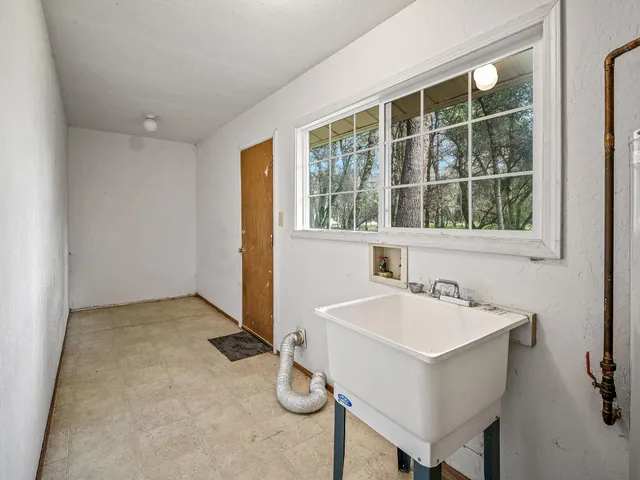 a view of a house with a yard and covered with trees