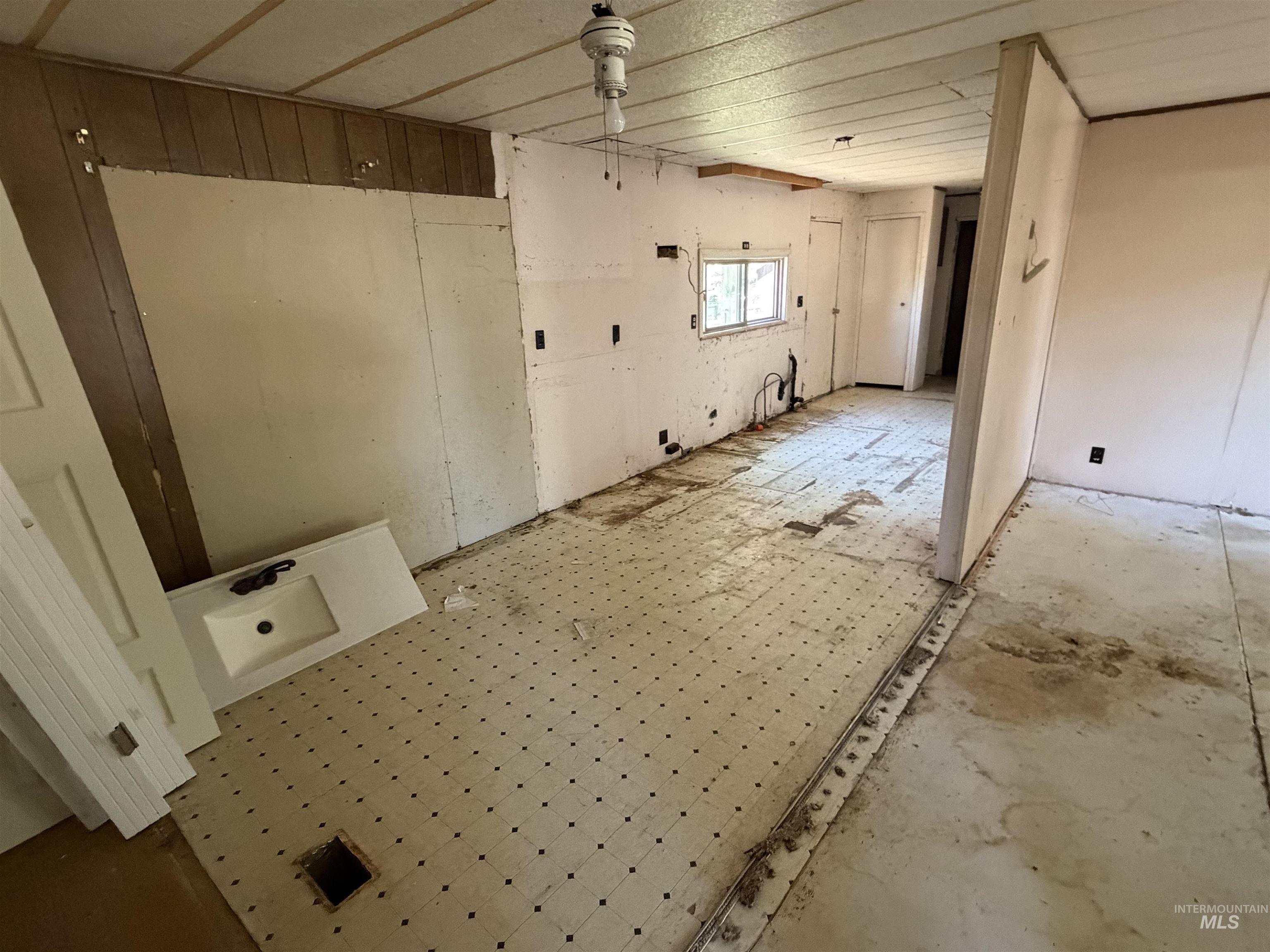 770 Dolson Lane Eagle, ID 83616 - Photo 11 of 11 Interior space featuring vinyl flooring, partial wood paneling, and an exposed window opening