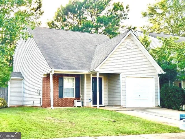 a view of a house with a yard and sitting area