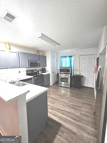 a open kitchen with kitchen island a sink stove and refrigerator