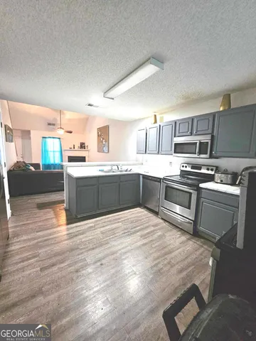 a kitchen with stainless steel appliances granite countertop a stove top oven and sink