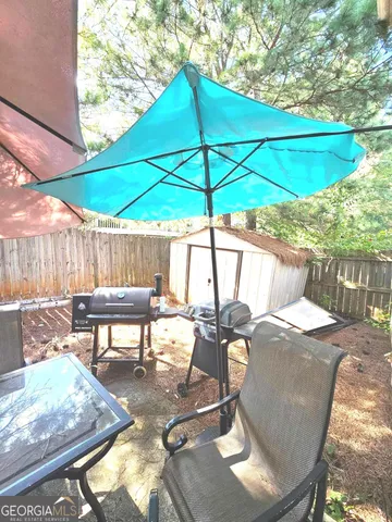 a view of a patio with table and chairs under an umbrella