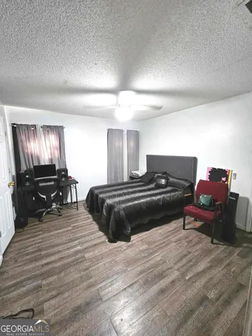 a spacious bedroom with a bed and a flat screen tv