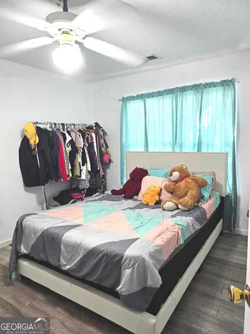 a bedroom with a bed and a painting on the wall