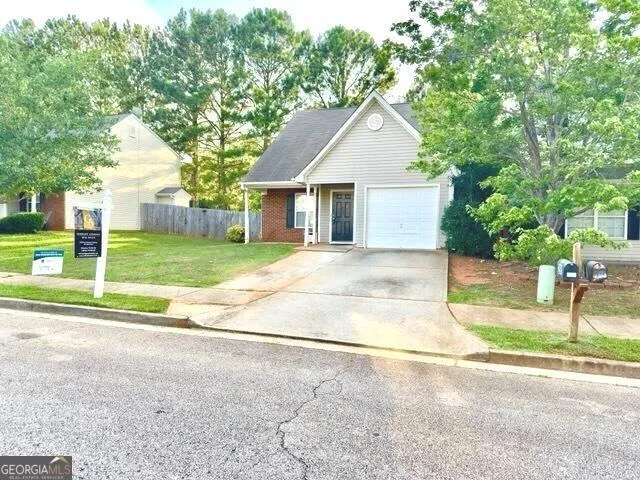 a view of a house with a yard and large tree