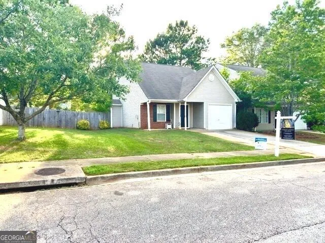 a view of a house next to a big yard with large trees
