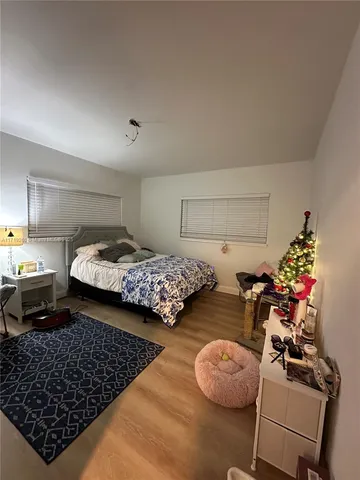 a bedroom with two beds and a potted plant