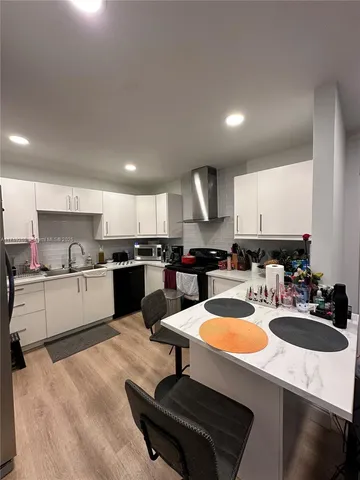 a kitchen with a sink a stove a counter space and chairs