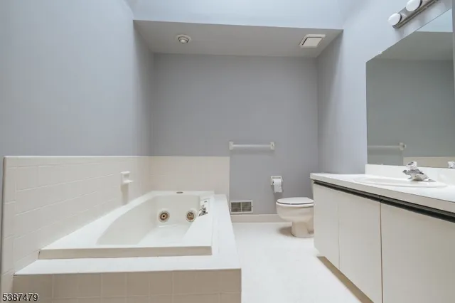 a bathroom with a bathtub sink mirror and toilet