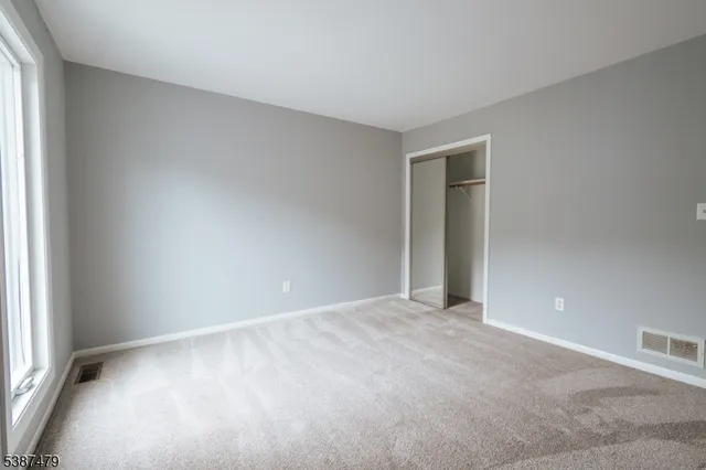 an empty room with an entryway and window