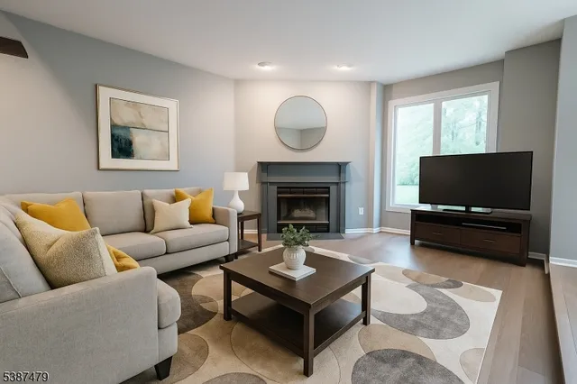a living room with furniture a flat screen tv and a fireplace