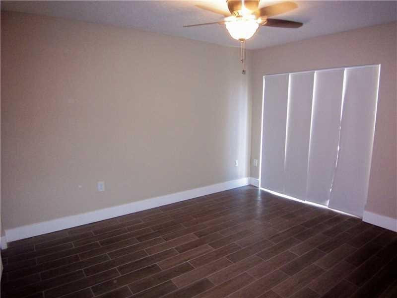 12031 Southwest 7th Street Miami, FL 33184 - Photo 6 of 12 a view of an empty room with wooden floor and a chandelier fan