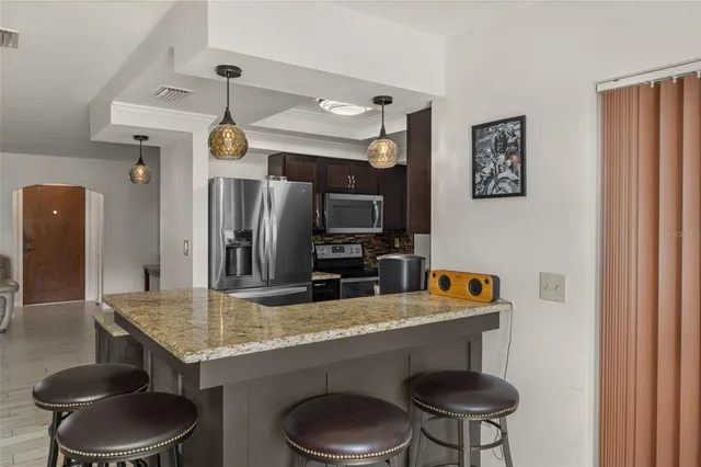 a kitchen with stainless steel appliances granite countertop a sink a stove and a refrigerator