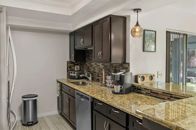 a kitchen with stainless steel appliances granite countertop a sink stove and refrigerator