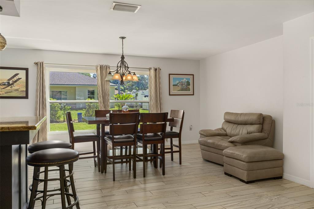7606 Landmark Drive Spring Hill, FL 34606 - Photo 15 of 41 a dining room with furniture a chandelier and wooden floor