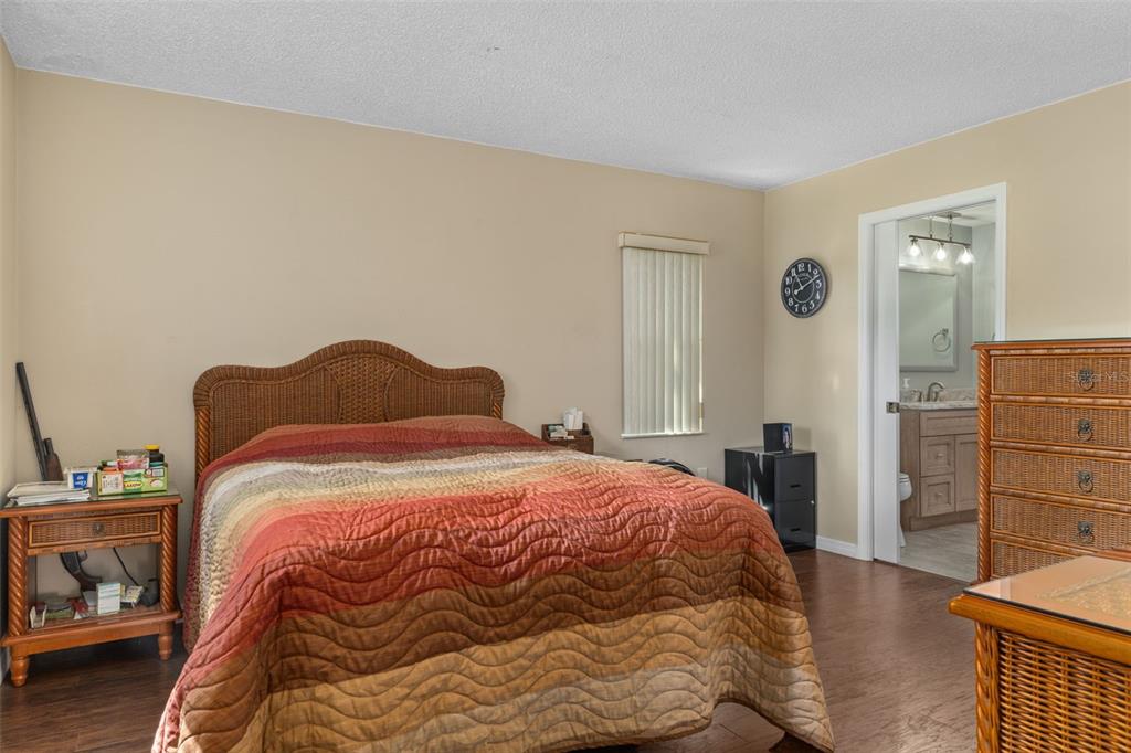 7606 Landmark Drive Spring Hill, FL 34606 - Photo 17 of 41 a bedroom with a bed and wooden floor