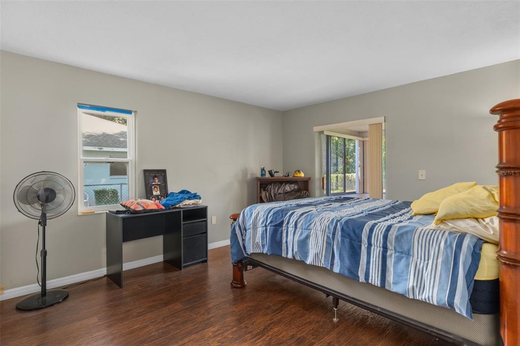 7606 Landmark Drive Spring Hill, FL 34606 - Photo 22 of 41 a bedroom with a bed and a chandelier