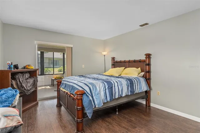 a bedroom with bed and wooden floor