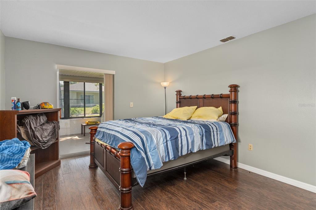 7606 Landmark Drive Spring Hill, FL 34606 - Photo 23 of 41 a bedroom with bed and wooden floor