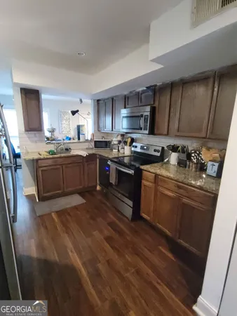 a kitchen with stainless steel appliances granite countertop a stove a sink dishwasher and a refrigerator