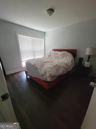 a bedroom with bed and wooden floor