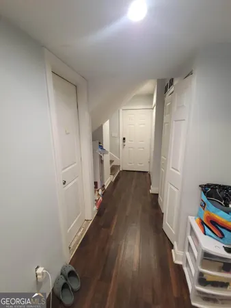 a view of a hallway with wooden floor and closet