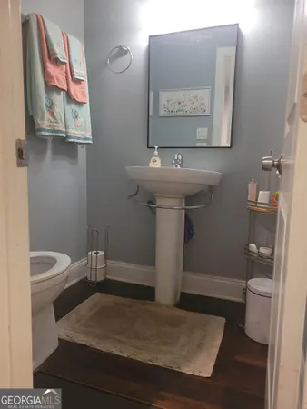 a bathroom with a toilet sink and mirror