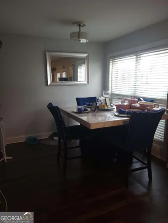 a kitchen with a table chairs and wooden floor