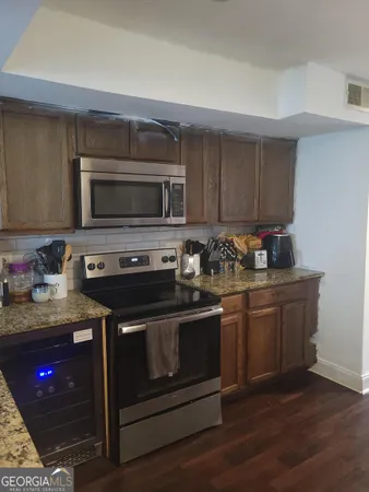 a kitchen with stainless steel appliances granite countertop a stove microwave and sink
