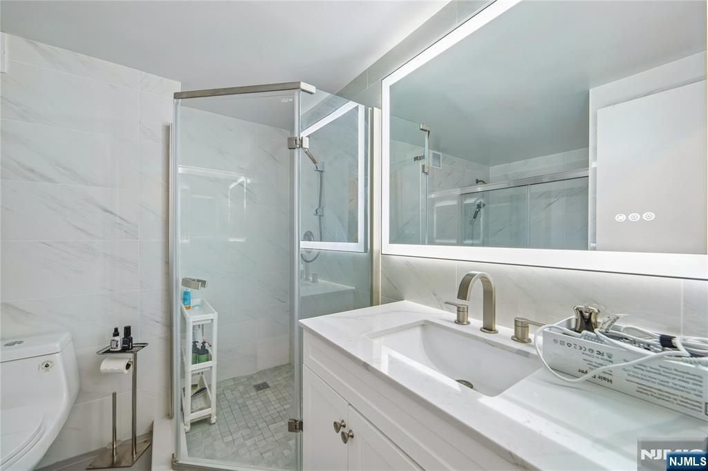 1055 River Road, Unit 302 Edgewater, NJ 07020 - Photo 7 of 17 a bathroom with a sink and mirror