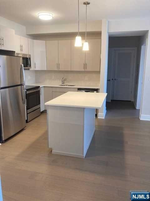 461 Palisades Boulevard, Unit 303 Fort Lee, NJ 07024 - Photo 8 of 13 a kitchen with a stove a refrigerator and a sink