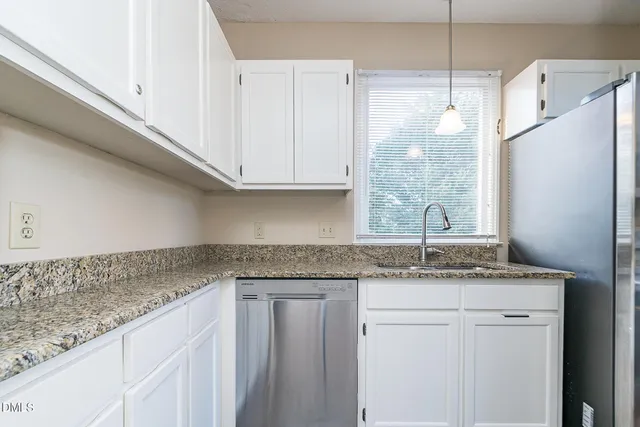 a kitchen with granite countertop a sink and cabinets