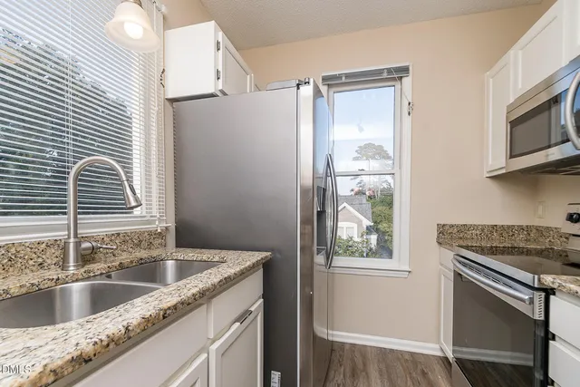 a kitchen with granite countertop a sink and a window