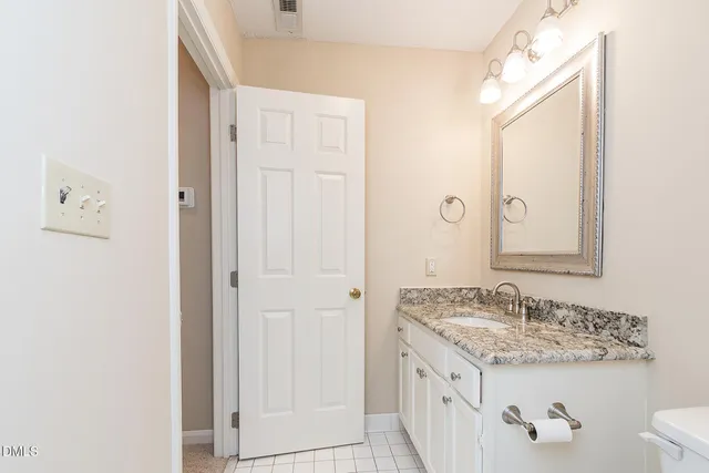 a bathroom with a granite countertop sink and a mirror