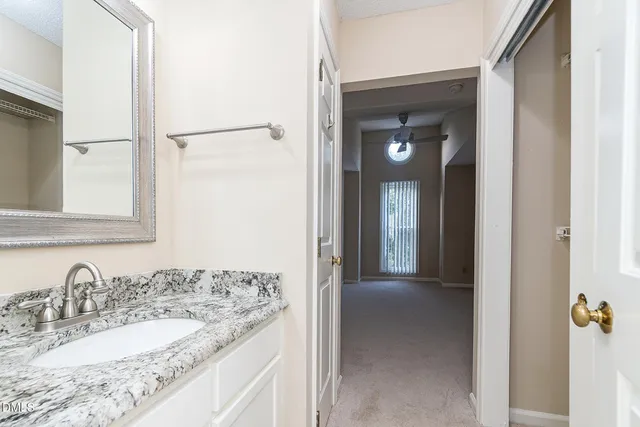 a bathroom with a granite countertop sink and a mirror