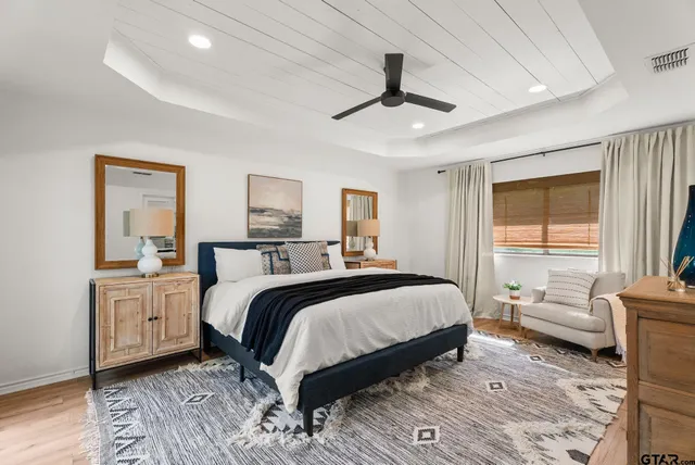 a bedroom with a large bed and a chandelier